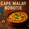 Traditional Cape Malay Bobotie with golden custard topping in a ceramic dish