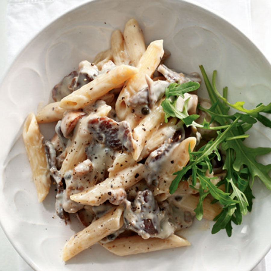 Biltong Potjie cooking with onions mushrooms green peppers tomato sauce pasta and cheese in potjie pot