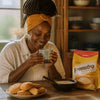 South African Food Culture featuring a woman in a headwrap holding a mug beside a Pronuto cappuccino mix and biscuits.