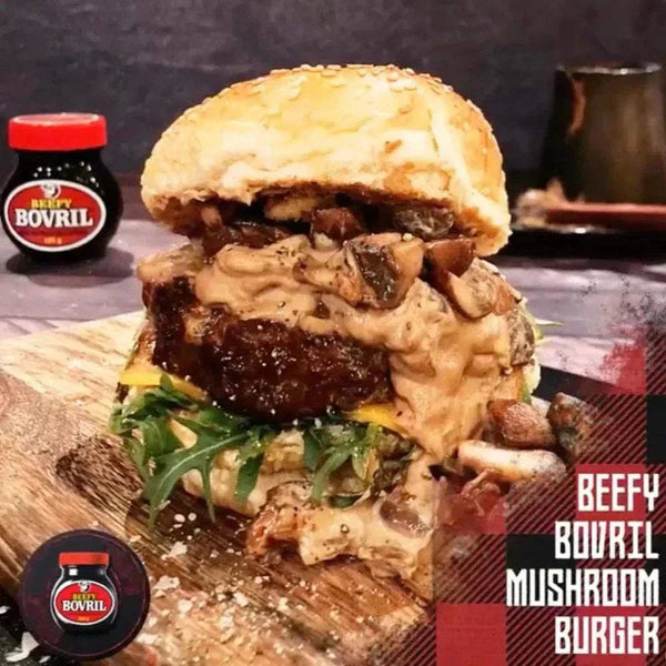 Beefy Bovril 125g jar with a beef mushroom burger topped with creamy sauce and fresh greens on a wooden board