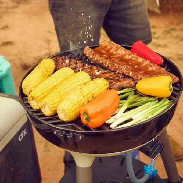 Portable CADAC Carri Chef 40 gas BBQ grilling corn, peppers, and meat outdoors.