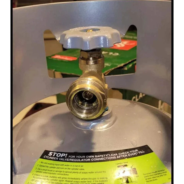 Gas BBQ valve connection with safety instructions on a propane tank.