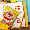 Willards Cheese Curls 150g bag with yellow packaging on a study desk with pencils and paper.