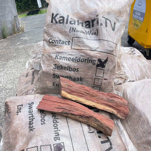 Camel Thorn Firewood bags stacked, showcasing dense, high-quality wood ideal for efficient, low-smoke burning in fireplaces and outdoor cooking.