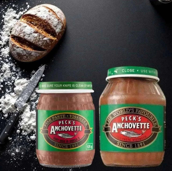 Peck's Anchovette Fish Paste 125g jars next to a loaf of bread, ideal for spreading.