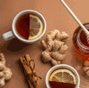 Freshpak Rooibos Tea with lemon slices, ginger, cinnamon sticks, and honey on a brown surface