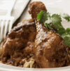 Peri-Peri spiced chicken drumsticks garnished with cilantro, served on a bed of rice.