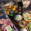Jan Braai Sauces Classic Lamb Potjie Sauce 400g with lamb meat, chopped onions, potatoes, green beans, black pepper, salt, and extra virgin olive oil ingredients for potjie cooking