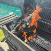 Burning Kameeldoring firewood in a grill, showcasing its low smoke and long-lasting heat.