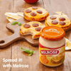 Melrose Cheese Spread - Cheddar 400g jar with toasted bagels topped with spread and pepperoni slices, wooden board background.