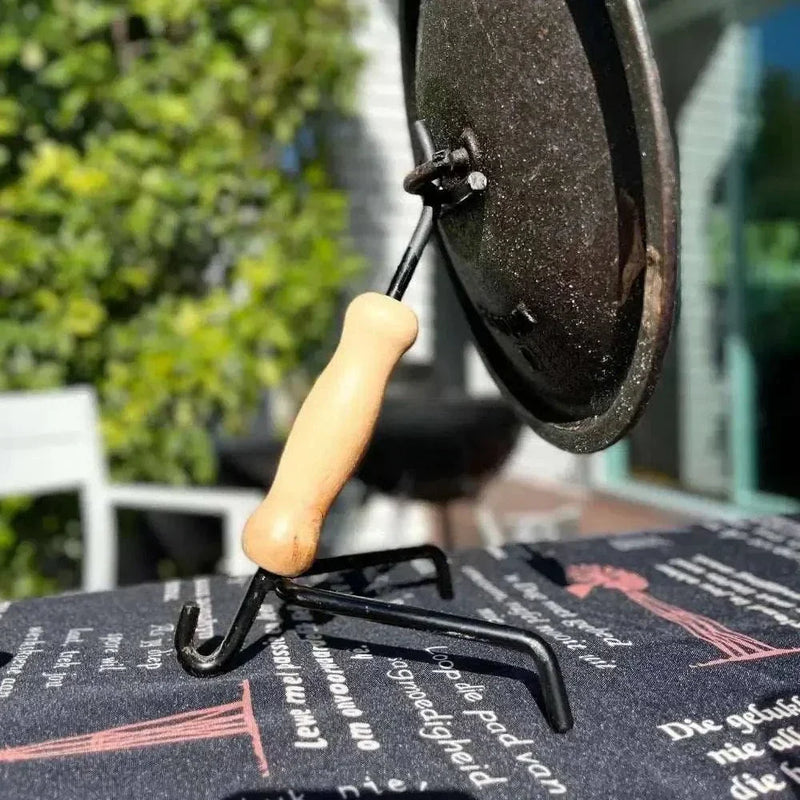 Steel and wood Potjie Multitool for lifting pot and lid safely during outdoor South African stew cooking