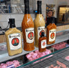 Rooibaard Groen Trui Chilli Sauce bottles on display in a shop setting.