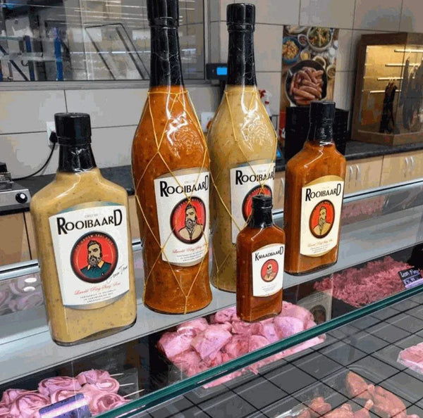 Rooibaard Groen Trui Chilli Sauce bottles on display in a shop setting.