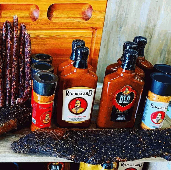 Rooibaard Kwaad Spice 170g bottle displayed with similar products on a wooden shelf.