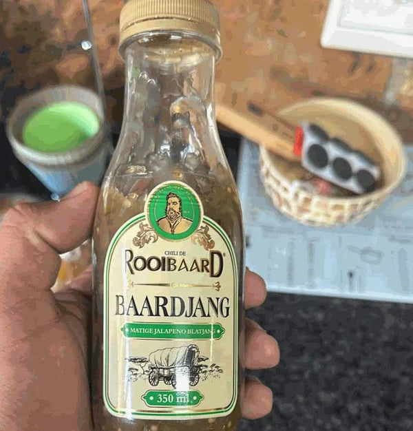 Rooibaard Sauce Baardjang Matige Jalapeno 350ml bottle held in hand, featuring mild jalapeno flavor.