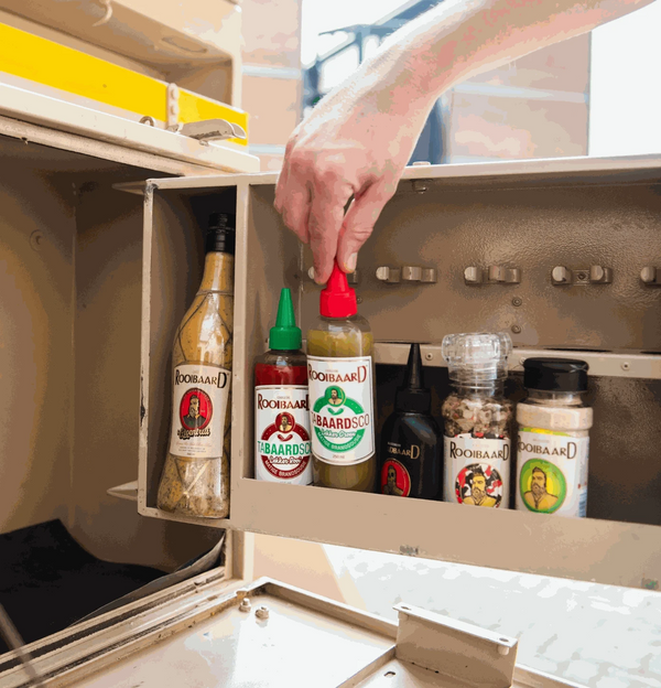 Rooibaard Tabaardsco Groen Sauce 250ml in cupboard with other seasonings.