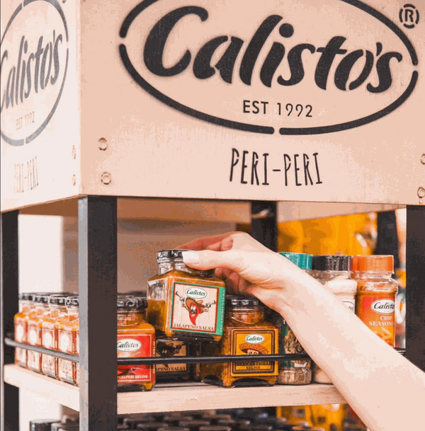 Calisto's Jalapeno Salsa on store shelf, hand picking jar, spicy salsa, flavorful dip.