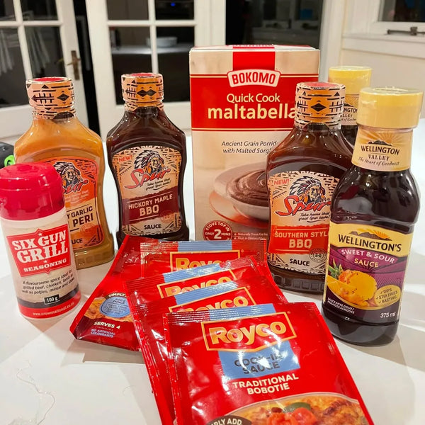 Royco Cook-in-Sauce Traditional Bobotie 50g packets with assorted barbecue and seasoning sauces on kitchen counter