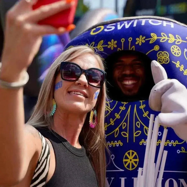 Switch Iron Brew Candy Floss Energy Drink 500ml can with festive design and people enjoying a lively event.