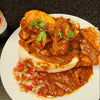 Durban Mutton Bunny Chow with spicy curry, bread, and fresh garnish on white plate