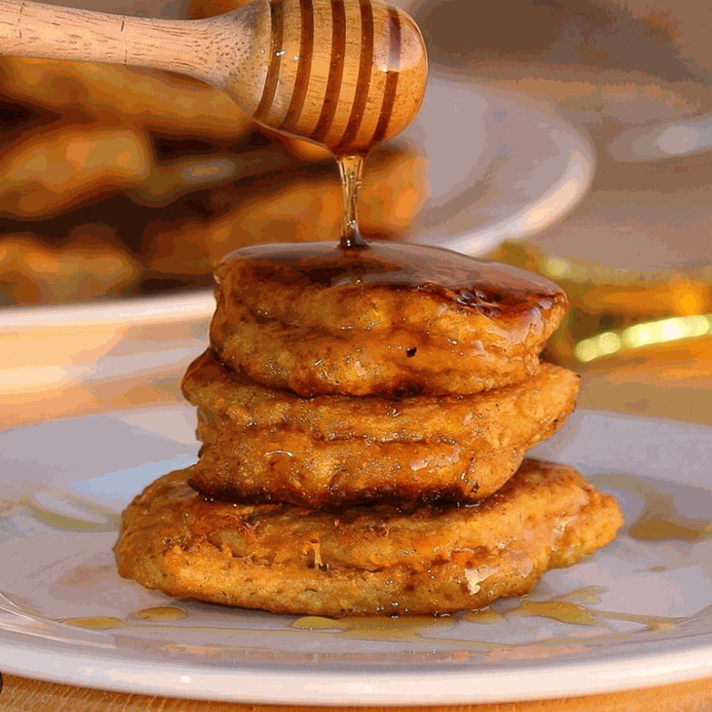 Close-up of golden gourmet pumpkin fritters served with cinnamon sugar on a rustic plate for Halloween treat