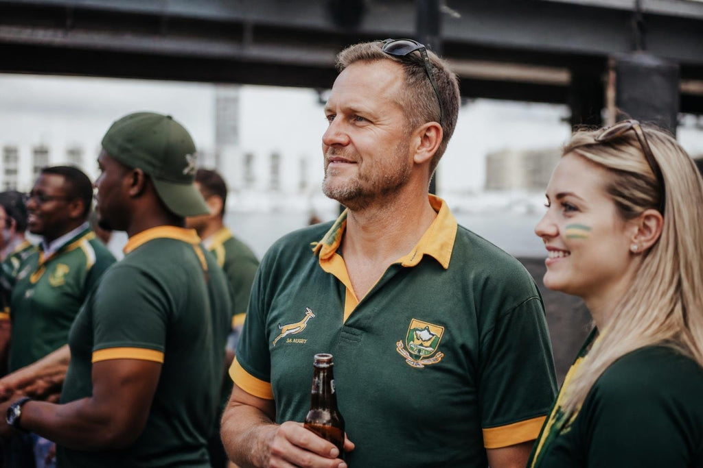 Springboks Jersey NZ in dark green polyester, with gold collar and sleeve trim and embroidered Springbok and team crests.