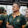 Springboks Jersey NZ in dark green polyester, with gold collar and sleeve trim and embroidered Springbok and team crests.
