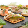 Bakers Cream Crackers with assorted toppings on a slate platter, highlighting their crunchy texture and buttery flavor.