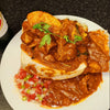 Durban Mutton Bunny Chow with spicy curry, bread, and fresh garnish on white plate
