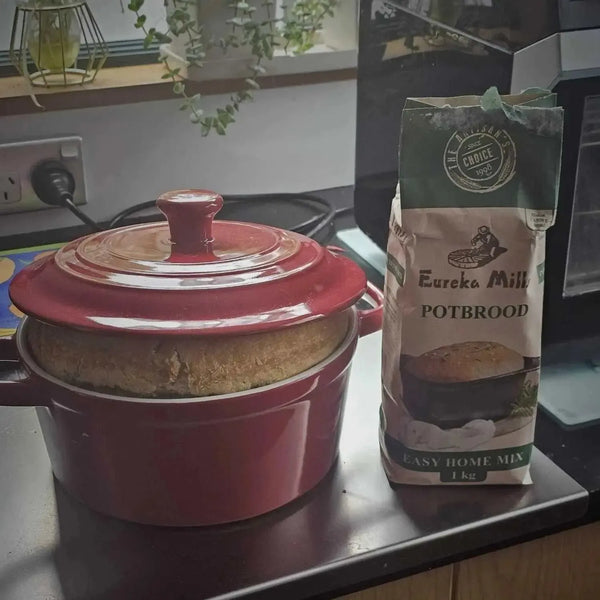 Eureka Mills Potbrood Easy Home Mix - 1kg next to freshly baked potbrood in red pot.