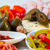 Jar of Ina Lessing green figs, 410ml, showcasing sweet fig preserves alongside assorted snacks.