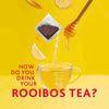 Freshpak Rooibos Tea tea bag pouring into cup with honey and lemon on yellow background