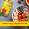 Freshpak Rooibos Tea box next to a berry and banana smoothie bowl with blueberries, strawberries, banana slices, kiwi, and granola on a gray surface