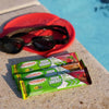 Futurelife High Energy chocolate strawberry crunch bars by the pool with sunglasses nearby.