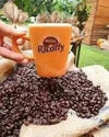 Nestle Ricoffy Mild Instant Coffee mug surrounded by coffee beans.