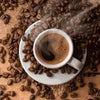 Cup of steaming instant coffee surrounded by coffee beans on a burlap cloth surface.