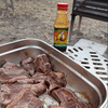 Jimmy's Sauce Steakhouse with raw steaks in a tray during a barbecue.