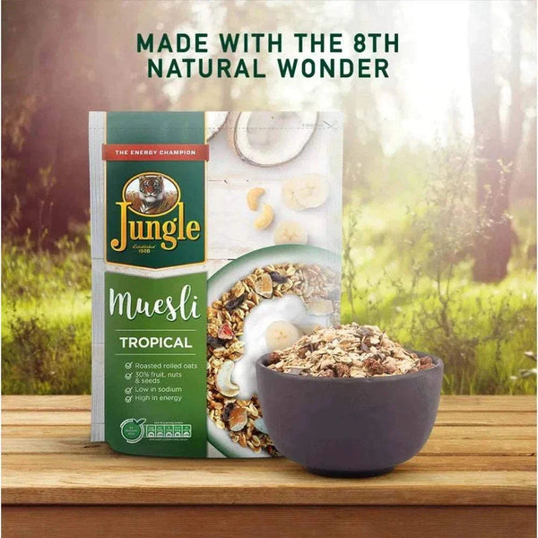 Jungle Muesli Tropical 750g pack with a bowl of muesli on a wooden surface, showcasing ingredients like oats, nuts, and dried fruits.