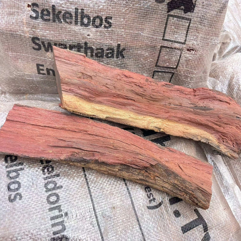 Camel Thorn firewood pieces on Kameeldoring bag for efficient home heating.