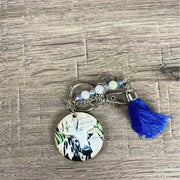 Wooden circle key tag with black and white cow and navy tassel