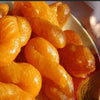 Close-up of golden fried South African Koeksisters soaked in syrup, ready-to-eat pack of 12 on a plate