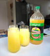 Mazoe Orange Crush - 2 Litre bottle with three glasses of citrus-flavored drink.