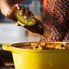 Mrs Balls Chutney Hot 470g being poured into a yellow pot, ideal for adding spice to meals.
