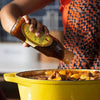 Mrs Balls Original Chutney being poured into a yellow pot during cooking.