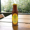 Mrs Balls Peach Chutney 470g bottle on a wooden table.