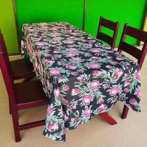 Black tablecloth with vibrant pink proteas, 275cm x 140cm, ideal for 6-8 seater tables