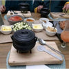 Traditional 3-legged cast iron pot with lid and handle for outdoor cooking over fire